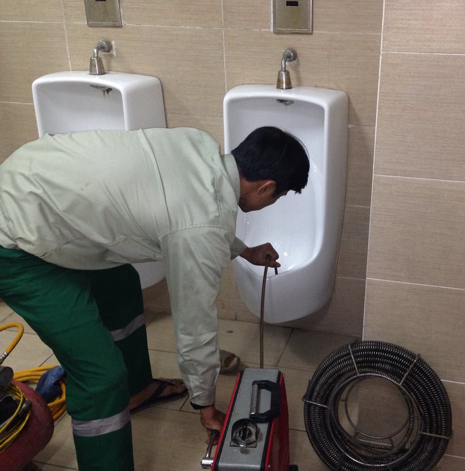Chuyên viên kỹ thuật đang xử lý mùi hôi nhà vệ sinh bằng thiết bị chuyên dụng
